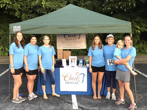 Photo of six Cheek Dental team members in wearing blue t-shirts. They are supporting East Cobb Rotary Club’s Dog Days Run.
