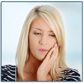 Woman holding her jaw in pain in need of an emergency dentist.