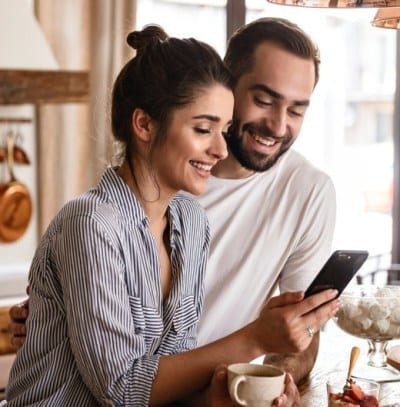 photo of a man and a woman looking at a virtual smile consult video on a mobile phone