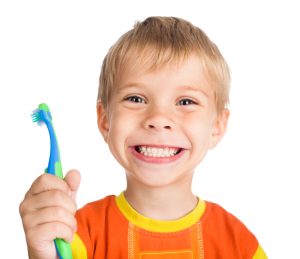 Boy smiling while holding a toothbrush